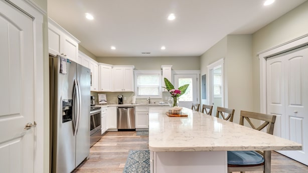 A modern kitchen with white cabinets, stainless steel appliances, and a marble island. - Chic Spring City Townhome on Watts Bar Lake! (Spring City)
