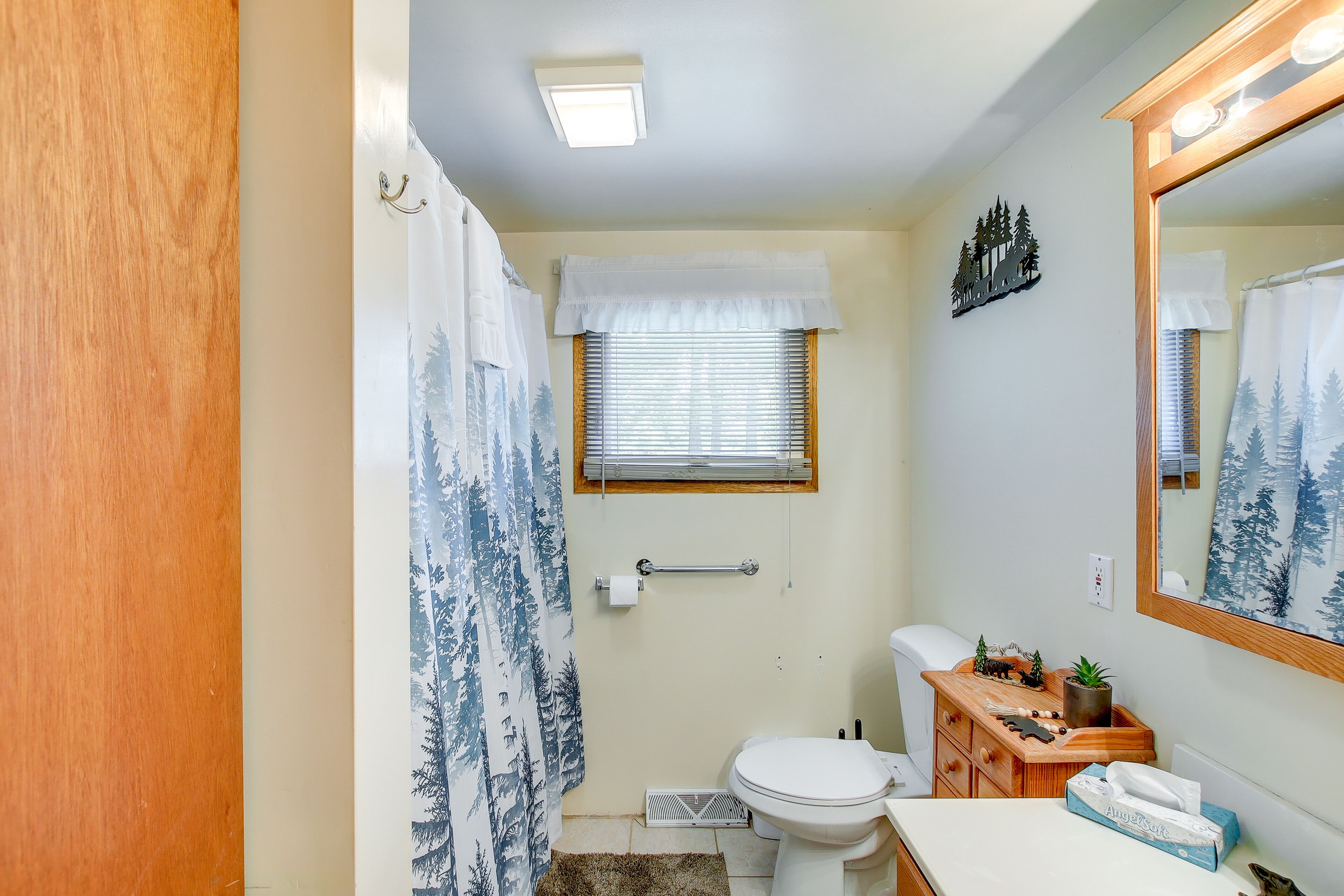 Une salle de bain avec des toilettes, un lavabo et un miroir.
