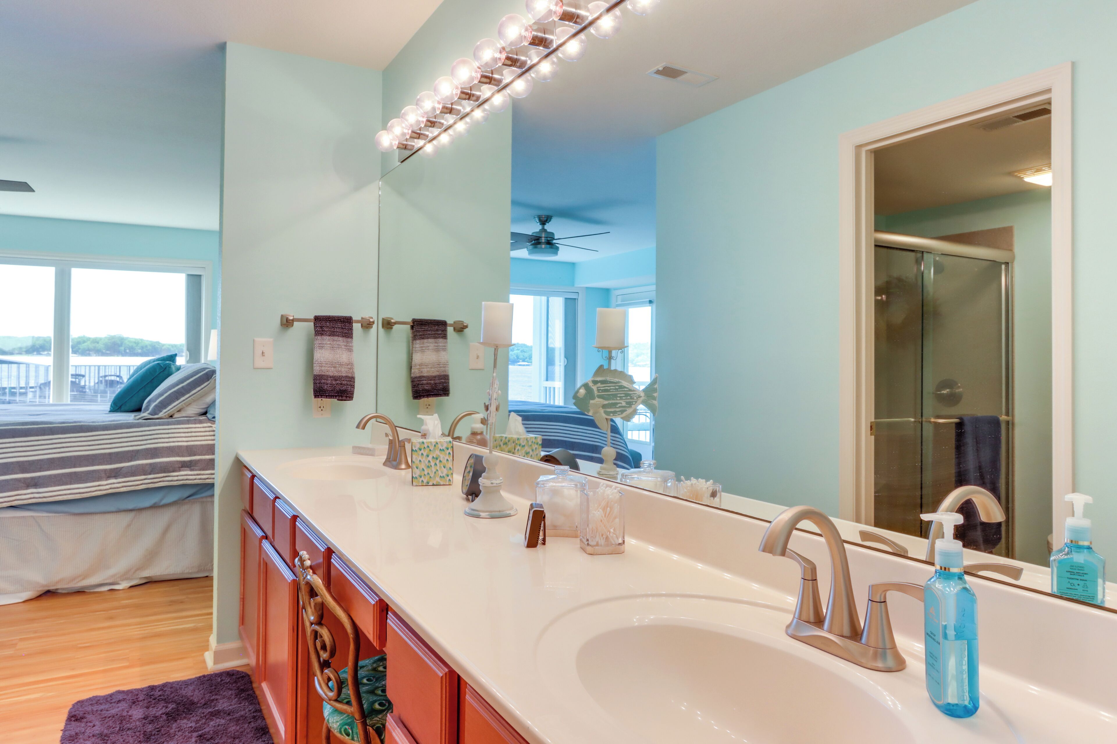 A bathroom with a large mirror, a sink, and a shower.