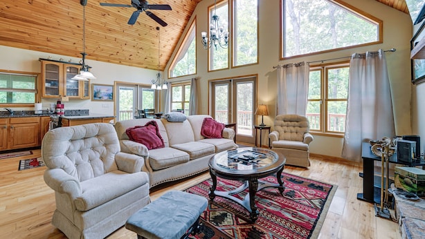 A spacious living room with a high ceiling, large windows, and a cozy fireplace. - Marble Mountainside Escape w/ Wraparound Deck (Marble)