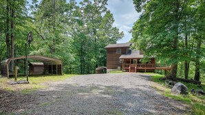 A rustic cabin with a gravel driveway, surrounded by dense forest. - Marble Mountainside Escape w/ Wraparound Deck (Marble)