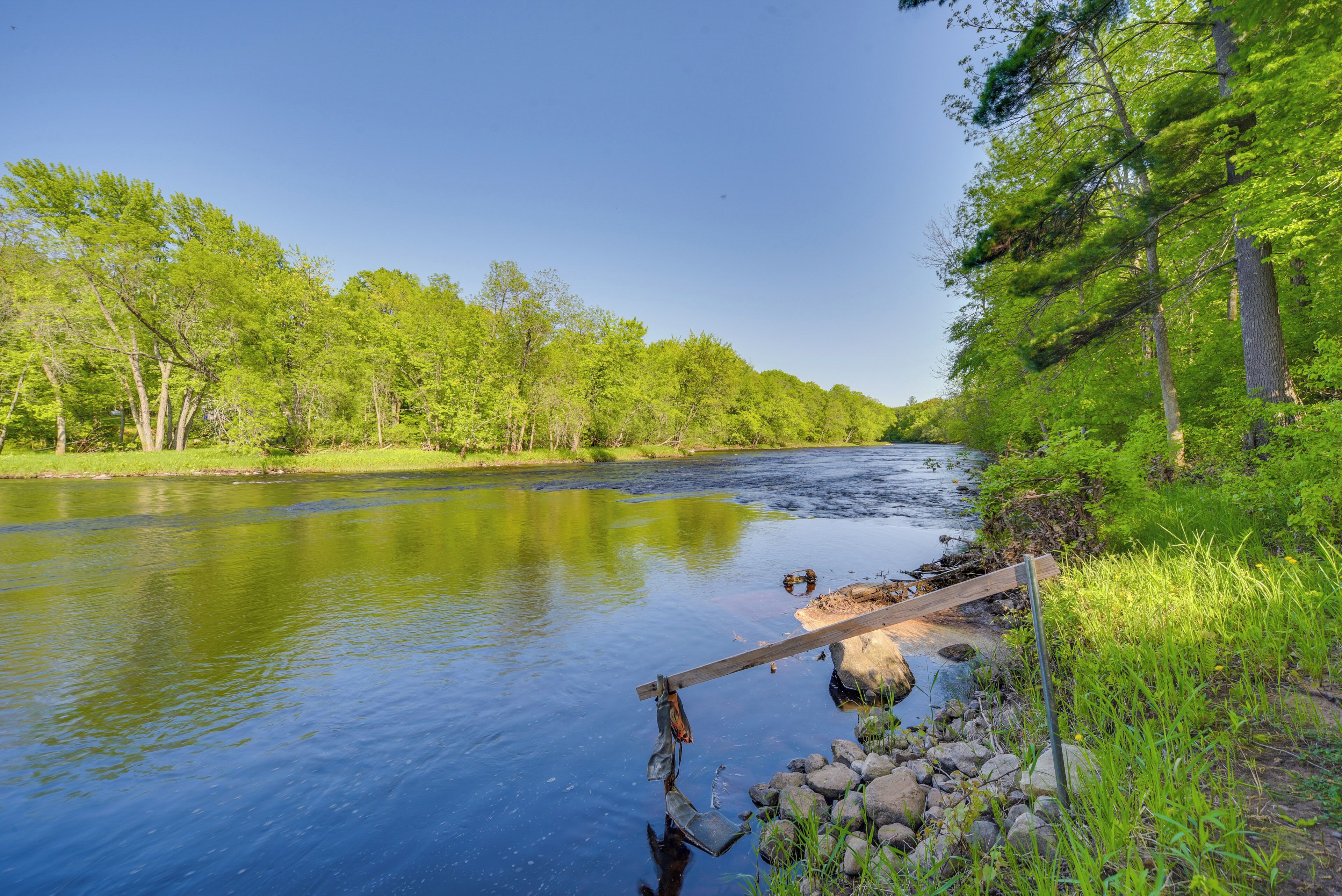 A river with a wooden bridge and rocks.