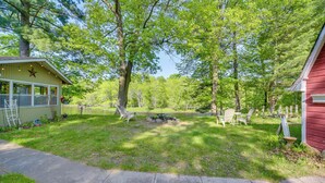 A backyard with a wooden deck, a small shed, and a pond. - Riverfront Nature Getaway Near Downtown Pine City! (Pine City)