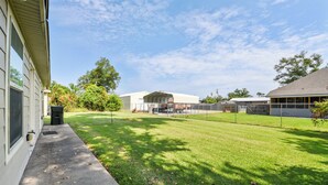 A residential property with a well-maintained lawn, a covered outdoor area, and a fenced yard. - Lovely Lake Charles Duplex in Central Location! (Lake Charles)