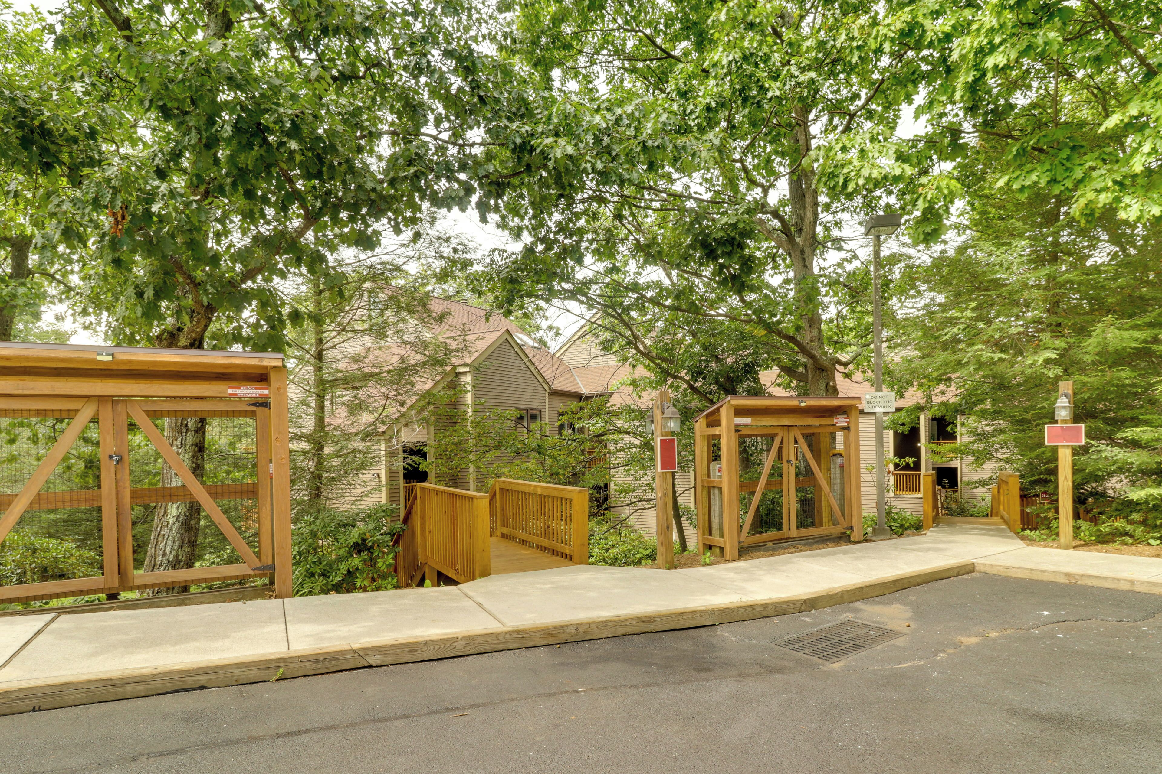 A gated entrance with wooden gates and a sidewalk leading to a building.
