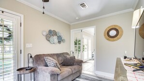 A living room with a sofa, a side table, a decorative wall piece, and a floor lamp. - Walk to Beach: Waveland Retreat w/ Yard! (Waveland)