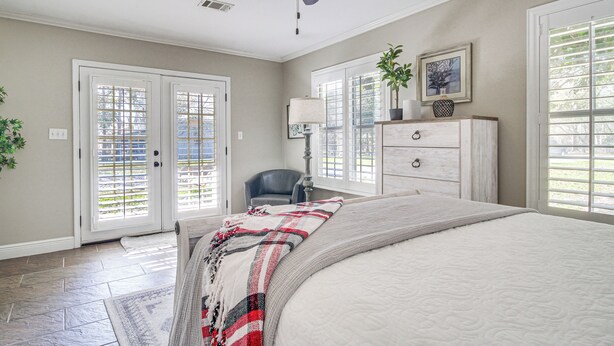 A bedroom with a bed, a ceiling fan, a dresser, a chair, and a window with blinds. - Walk to Beach: Waveland Retreat w/ Yard! (Waveland)