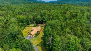 A lodge in a forested area with a clear view of the surrounding mountains. - Pet-friendly Conway Cabin ~ 5 to Campton Mountain! (Thornton)