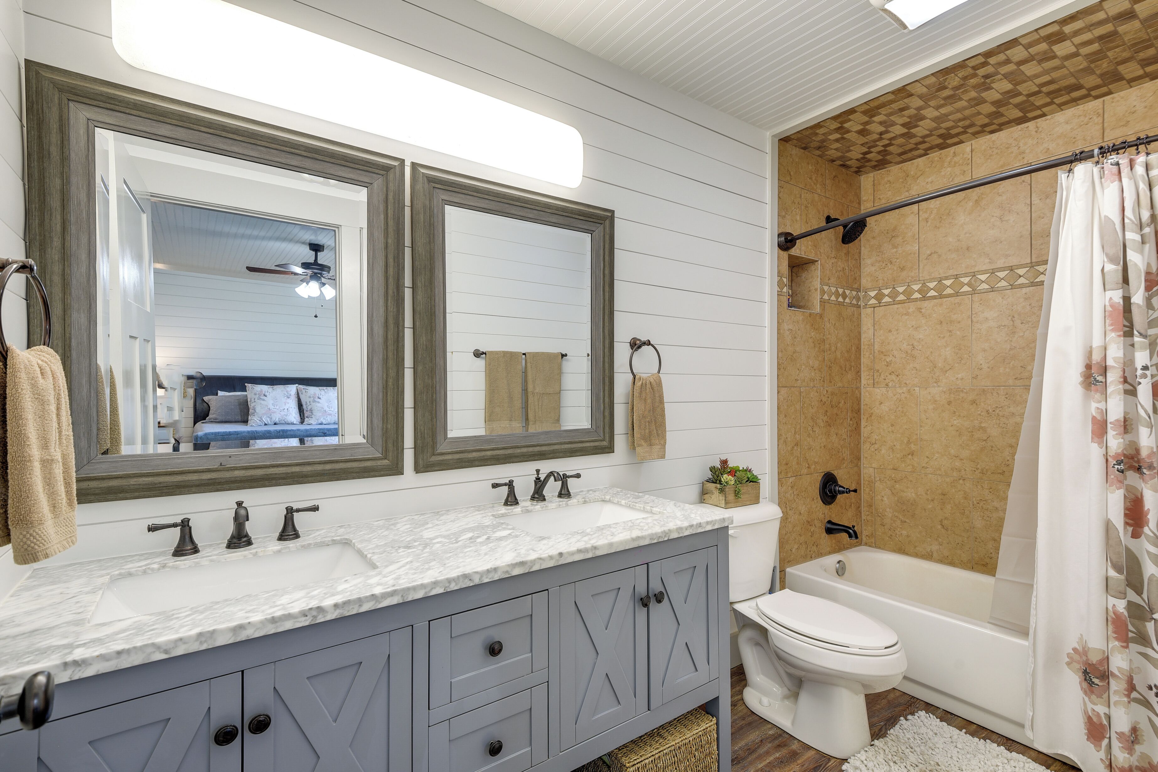 A bathroom with a double vanity, a toilet, and a bathtub.