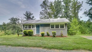 A small, single-story house with a front porch, a door, and a chimney.