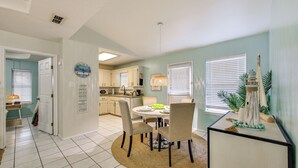 A dining area with a round table, chairs, and a kitchen in the background. - Welcoming Edinburg Apartment - Pet Friendly! (Edinburg)