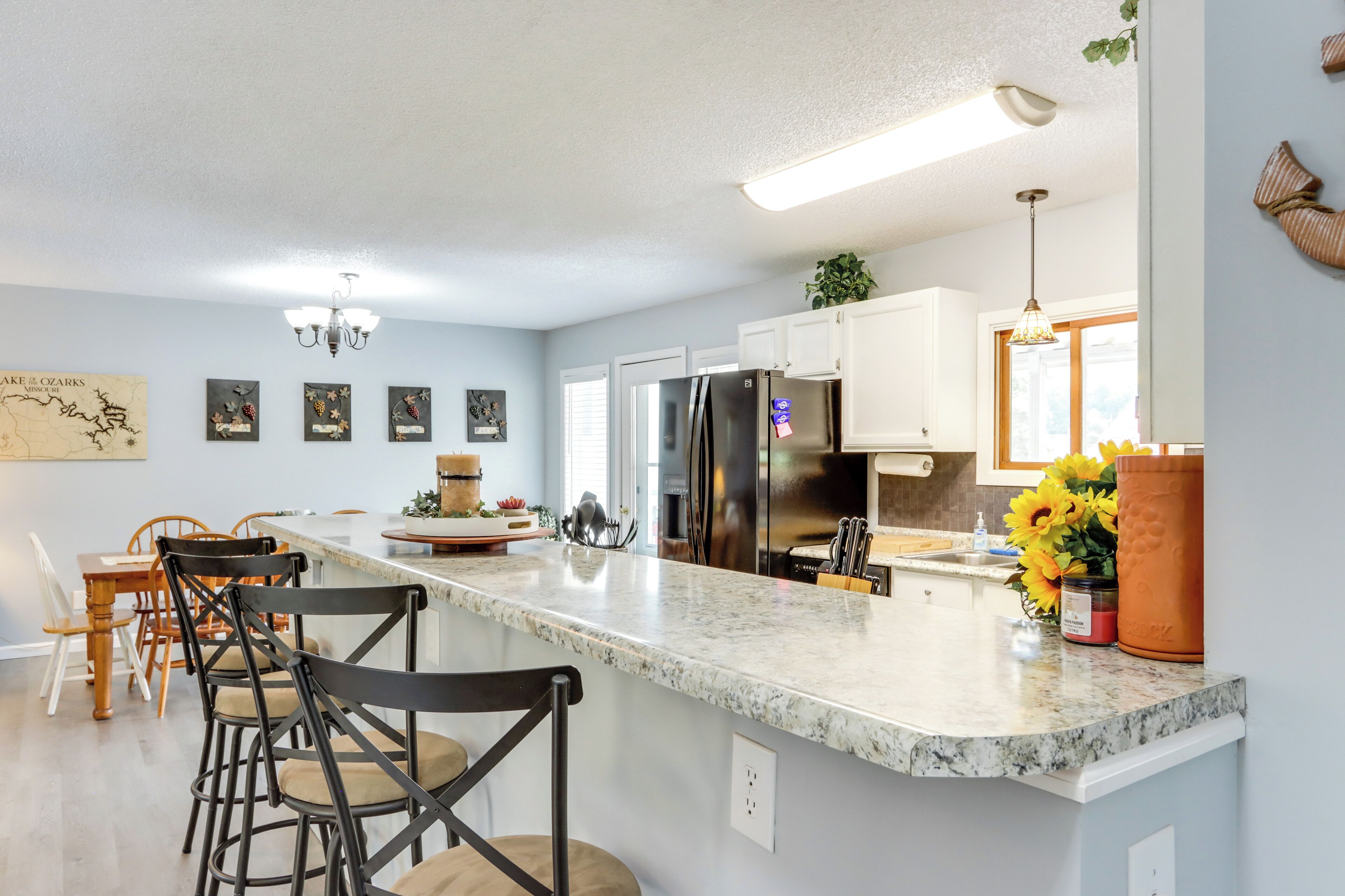 A modern kitchen with a large island, white cabinets, and stainless steel appliances.