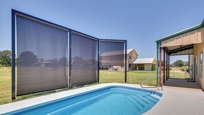 Une piscine à l’eau d’un bleu limpide, entourée d’un patio abrité.