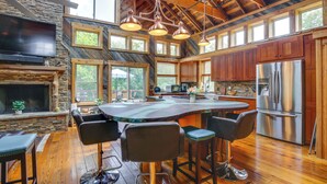 A spacious kitchen with a large island, wooden cabinets, and a stainless steel refrigerator. - Serene Pacific Getaway: Deck, Grill & Fire Pit! (Pacific)