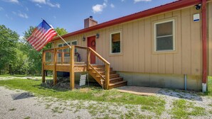 A two-story house with a wooden deck and a red door. - Serene Pacific Getaway: Deck, Grill & Fire Pit! (Pacific)