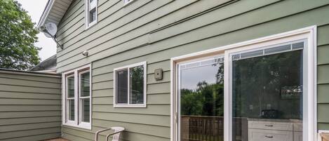 A wooden deck with a sliding glass door leading to a deck area.