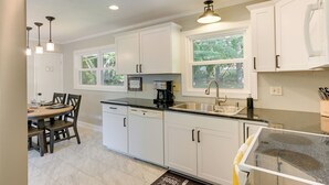 A modern kitchen with white cabinets, a black countertop, and a window above the sink. - Family-friendly Blacksburg Retreat w/ Playground! (Blacksburg)