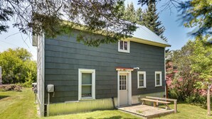 A two-story house with a front porch, a small deck, and a fenced yard. - Pet-friendly Michigan Getaway w/ Porch & Kayaks! (Ontonagon)