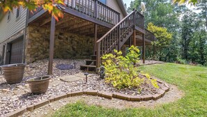 A house with a stone foundation, wooden deck, and a staircase leading to a second floor. - Cozy Hiwassee Vacation Rental w/ Yard (Hiwassee)
