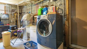A laundry room with a front-loading washing machine, a drying rack, and various cleaning supplies. - Cozy Hiwassee Vacation Rental w/ Yard (Hiwassee)