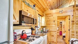 L’intérieur d’un chalet en bois comprend une cuisine équipée d’une cuisinière, d’un four, d’un four à micro-ondes et d’un réfrigérateur.