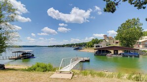 Una propiedad junto al lago con muelle, rampa de acceso cubierta para embarcaciones y una edificación con zona techada.