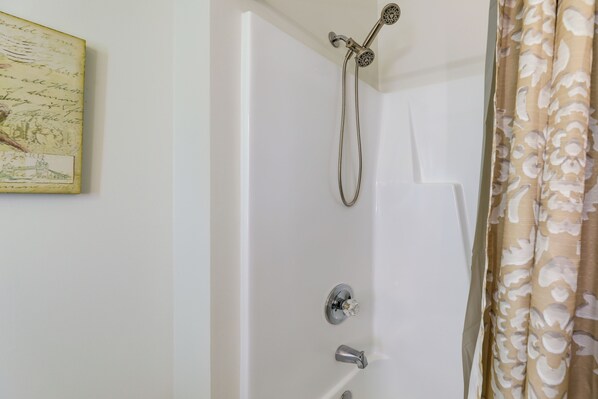 A bathroom with a shower, a toilet, and a sink.