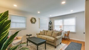 Un salon avec un canapé beige, une table basse et un tapis à motifs.