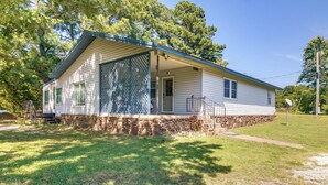 A single-story house with a stone foundation, a covered porch, and a screened window. - Cookson Vacation Rental w/ Spacious Yard & Porch! (Cookson)
