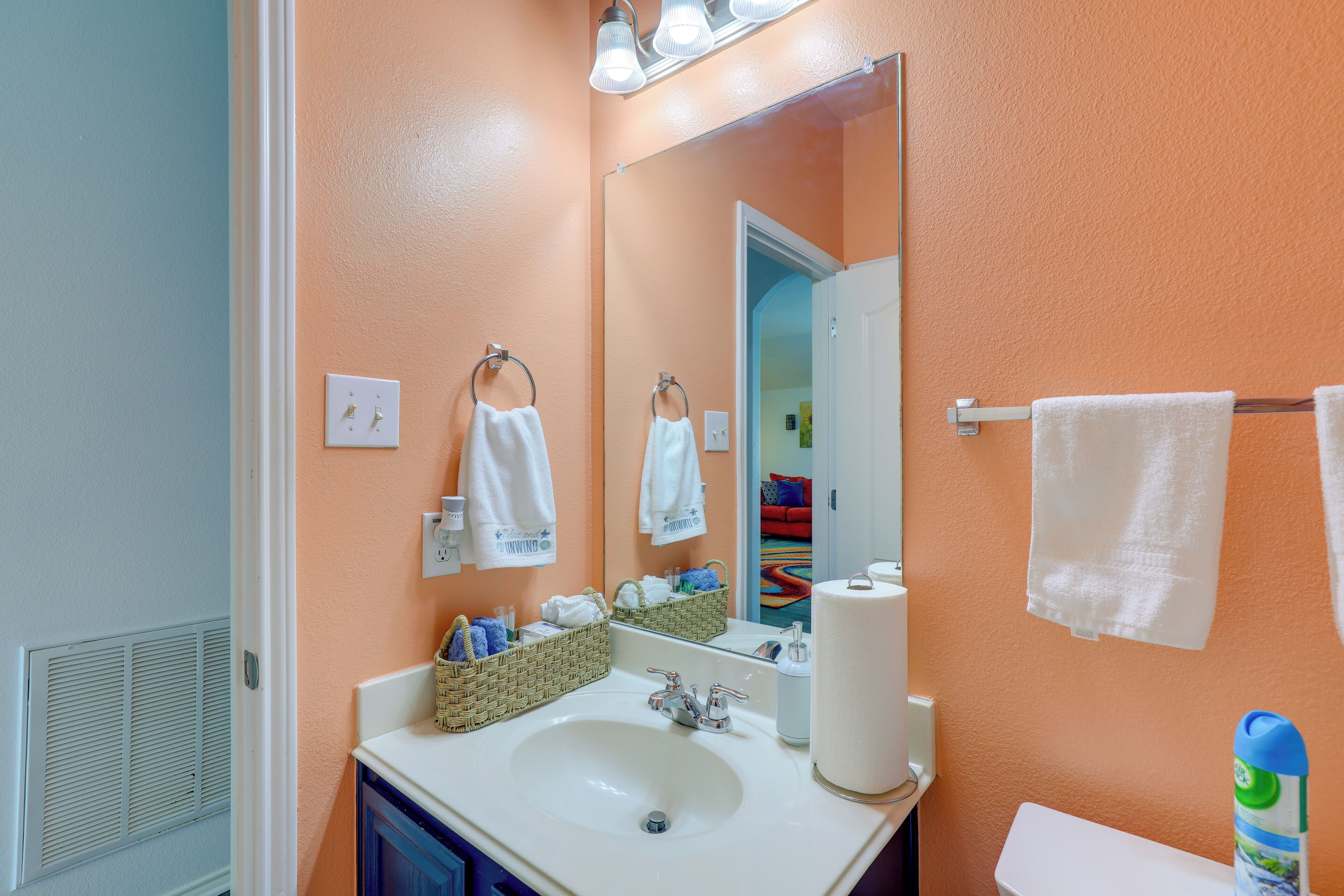 A bathroom with a white sink, a mirror, a towel rack, and a toilet.