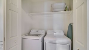 A laundry room with two white front-loading washing machines and a white shelf above them. - Charming Arkansas Getaway - Walk to Downtown! (Fort Smith)
