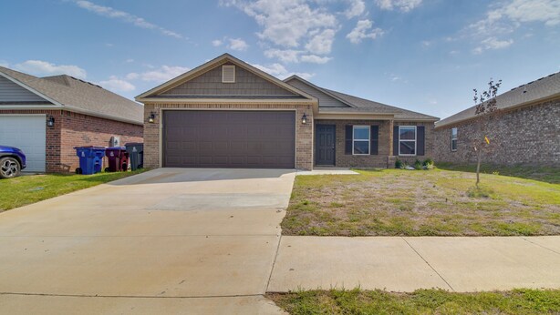 A residential house with a garage, a driveway, and a small lawn. - Charming Arkansas Getaway - Walk to Downtown! (Fort Smith)