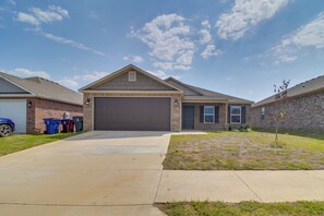 A residential house with a garage, a driveway, and a small lawn. - Charming Arkansas Getaway - Walk to Downtown! (Fort Smith)