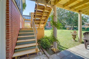 A wooden staircase leading to a covered porch with a brick wall on one side. - Historic Fort Smith Cottage < 1 Mi to Downtown! (Fort Smith)