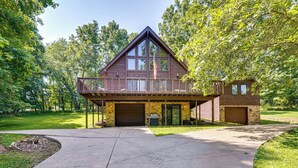 A two-story lodge with a balcony, large windows, and a garage. - Cabin w/ Deck ~ 3 Mi to Apple Valley Lake! (Howard)