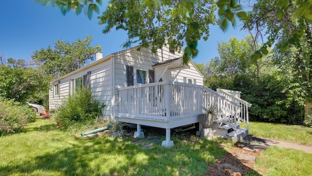 A white two-story house with a porch and a small deck. - Gillette Adventure Base 1 Mi to Historic Downtown! (Gillette)