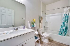 A bathroom with a white sink, mirror, toilet, and bathtub. - Jarrell Home w/ Playground + Pool Access! (Jarrell)