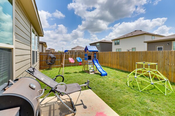 A backyard with a slide, a swing set, and a barbecue grill. - Jarrell Home w/ Playground + Pool Access! (Jarrell)