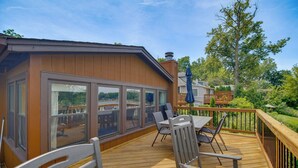 Eine Terrasse mit Gartenmöbeln, ein überdachter Patio-Bereich und Blick auf eine Wohngegend.