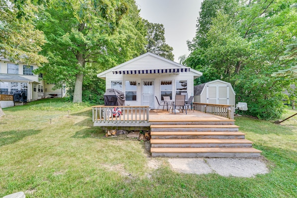A small house with a porch, a grill, and a covered outdoor seating area. - Lakefront Grant Cottage w/ Grill & Fire Pit! (Grant)
