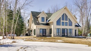 A large, two-story house with a steeply pitched roof and large windows. - Lakefront Grand Rapids Vacation Rental w/ Dock! (Grand Rapids)