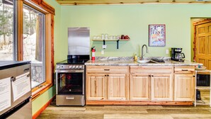 A kitchen with wooden cabinets, a stainless steel refrigerator, a stove, and a sink. - Pokegama Lake Vacation Rental w/ Shared Boat Dock! (Grand Rapids)
