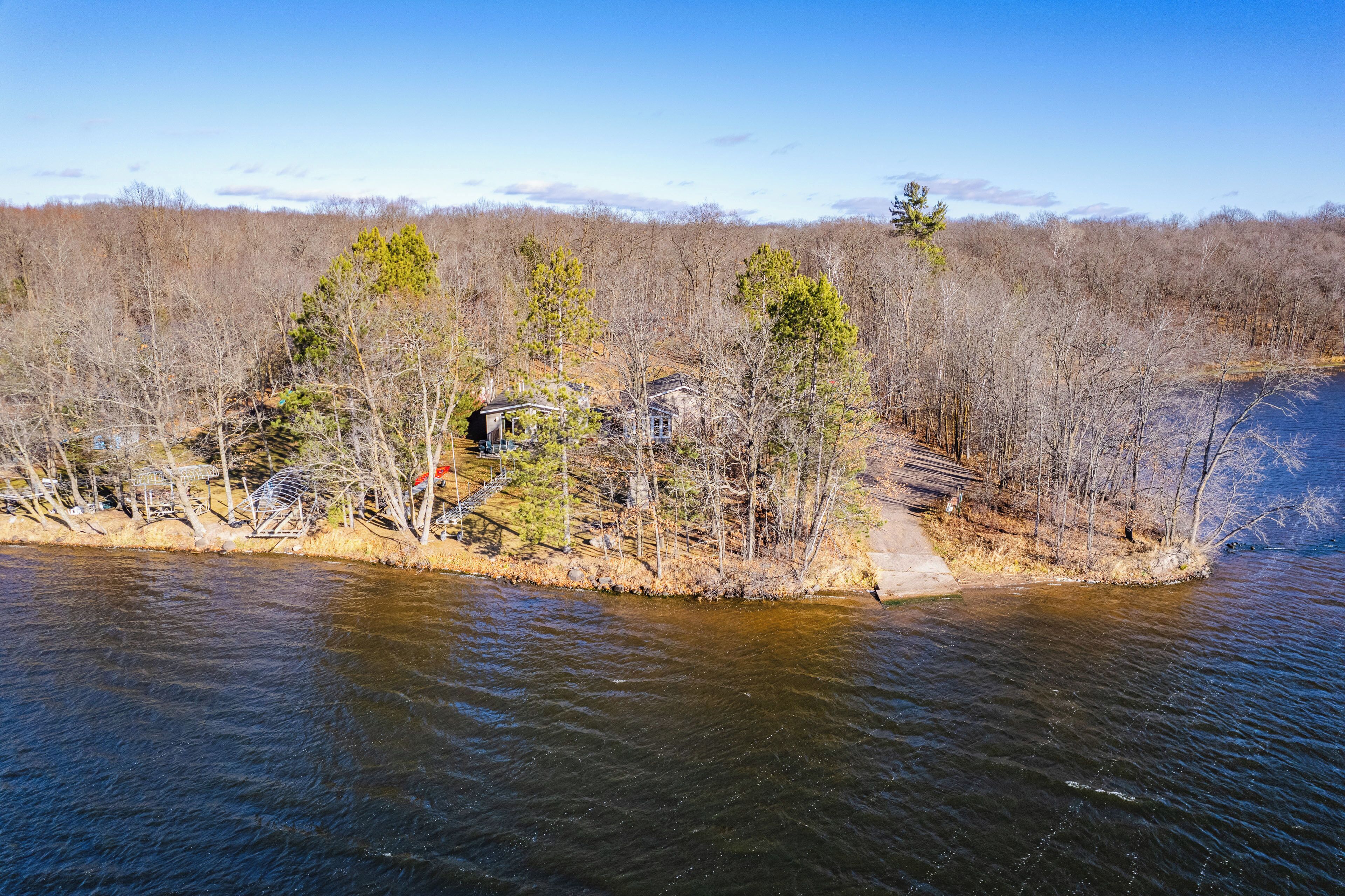 A riverside property with a dock, a small house, and a bridge.