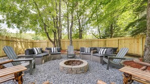 A backyard with a fire pit, outdoor furniture, and a wooden fence. - Spacious Old Forge Condo w/ Patio & Fire Pit! (Old Forge)