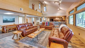 A spacious living area with a large brown leather sofa, a wooden coffee table, and a patterned rug. - Spacious Old Forge Condo w/ Patio & Fire Pit! (Old Forge)
