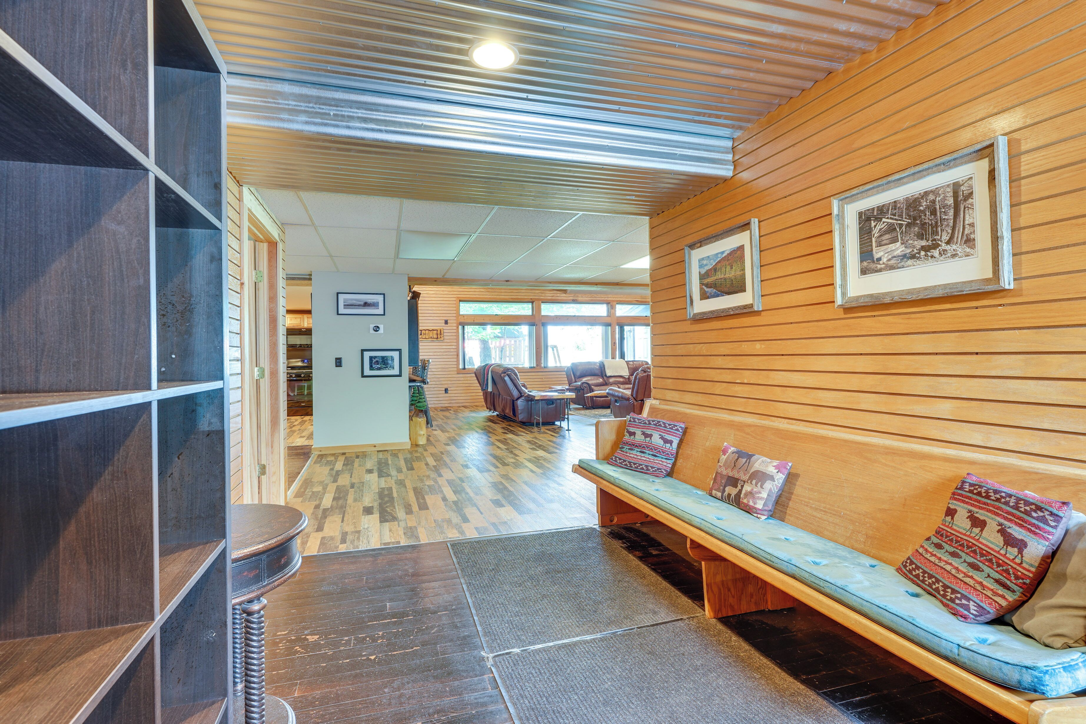 A lobby with a wooden bench, a reception desk, and framed artwork on the wall.