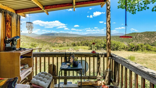 A wooden deck with a view of a mountainous landscape. - Scenic Mount Sopris View: Historic Alpine Cabin! (Glenwood Springs)