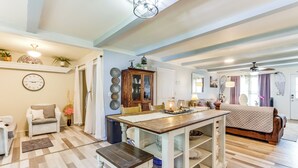 A spacious living area with a wooden dining table, a sofa, and a bed. There is a kitchen area with a refrigerator and a microwave. - Charming St James Home Near Maramec Spring Park! (St. James)