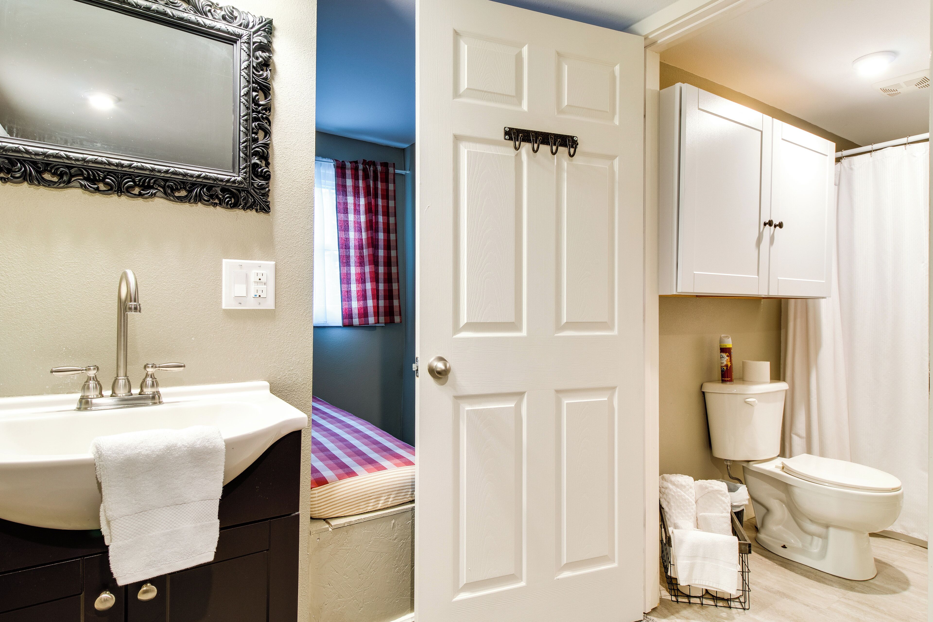 A bathroom with a sink, toilet, and a mirror.