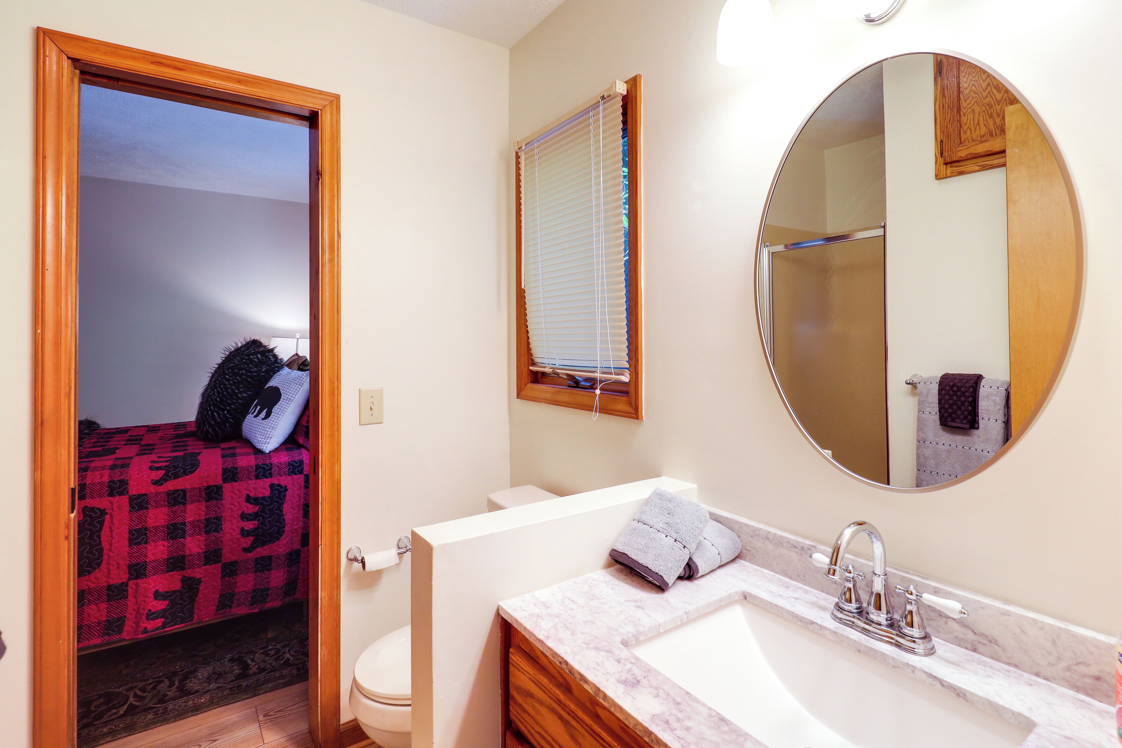 A bathroom with a sink, mirror, and toilet.